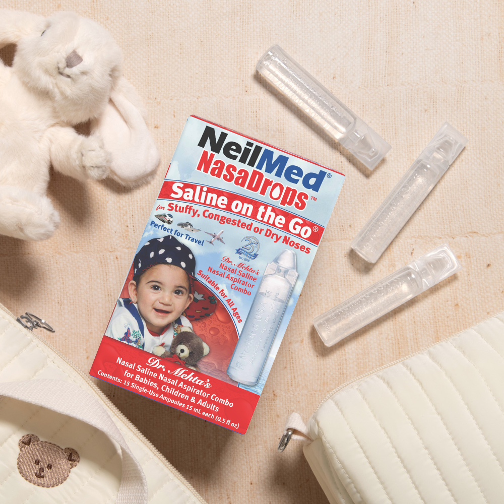 NeilMed Nasal Drops packaging with nasal aspirator on a beige background