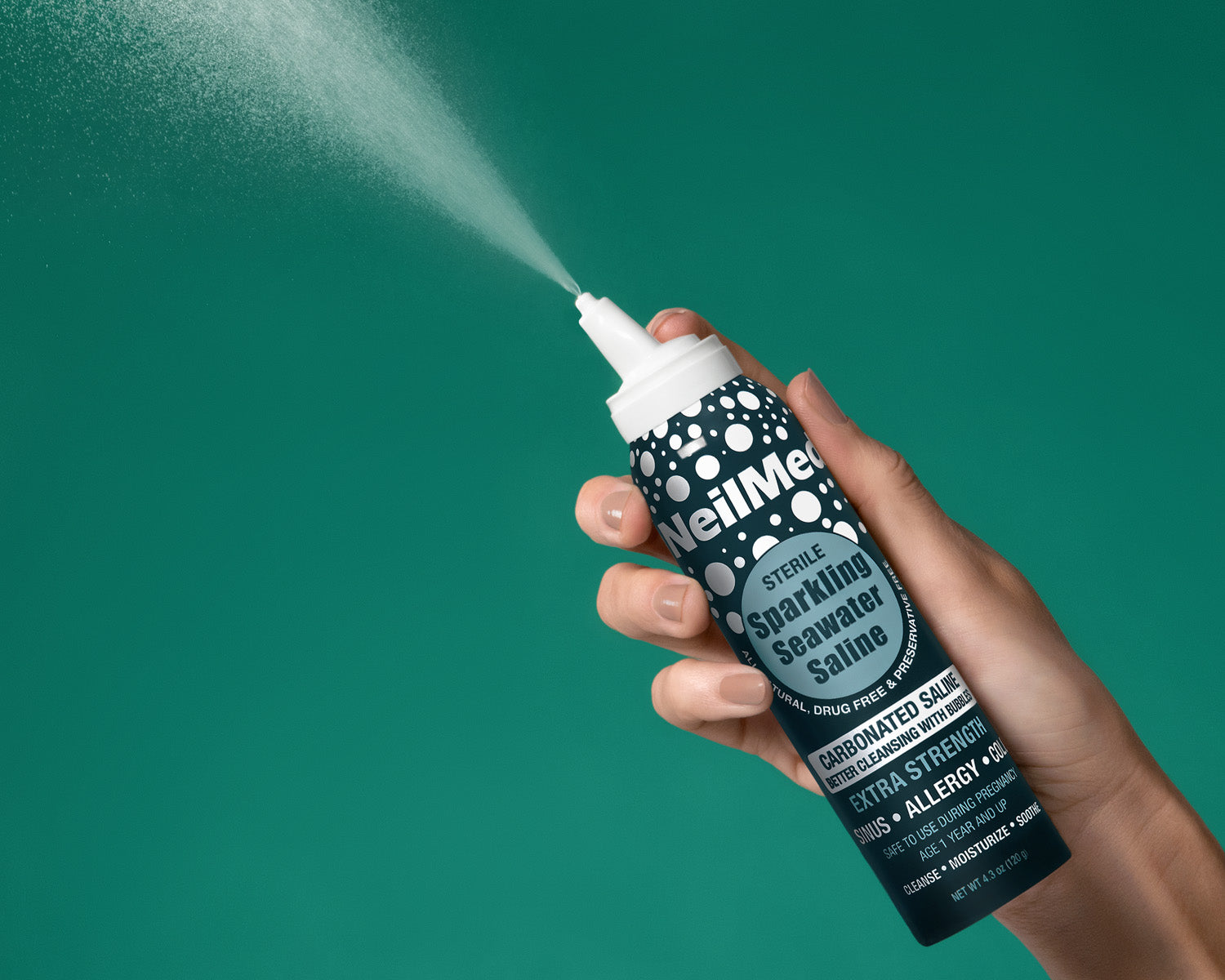Hand holding a NeulMe spray bottle against a teal background
